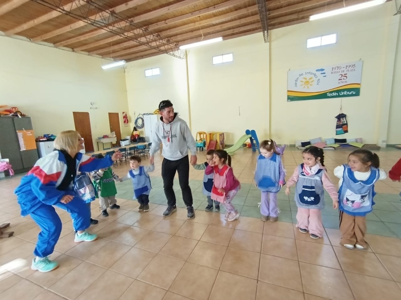 Actividad de educación física con niños y docentes en el salón del Jardín