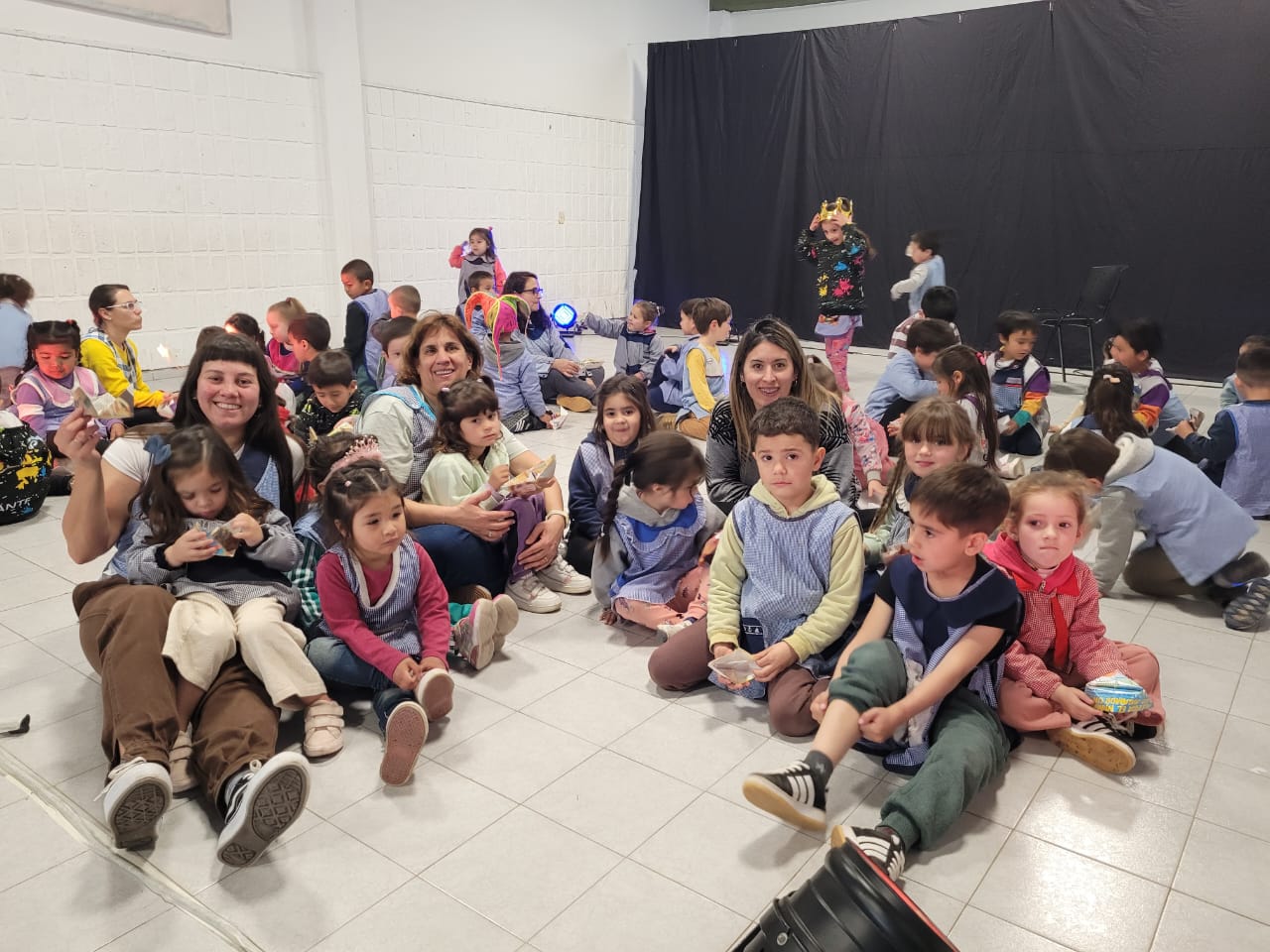Niños y adultos reunidos durante una actividad escolar