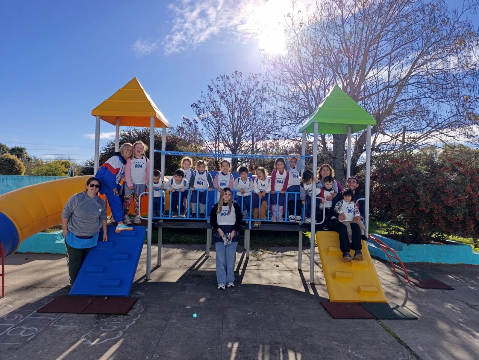 Grupo de niños y docentes en los juegos del patio exterior